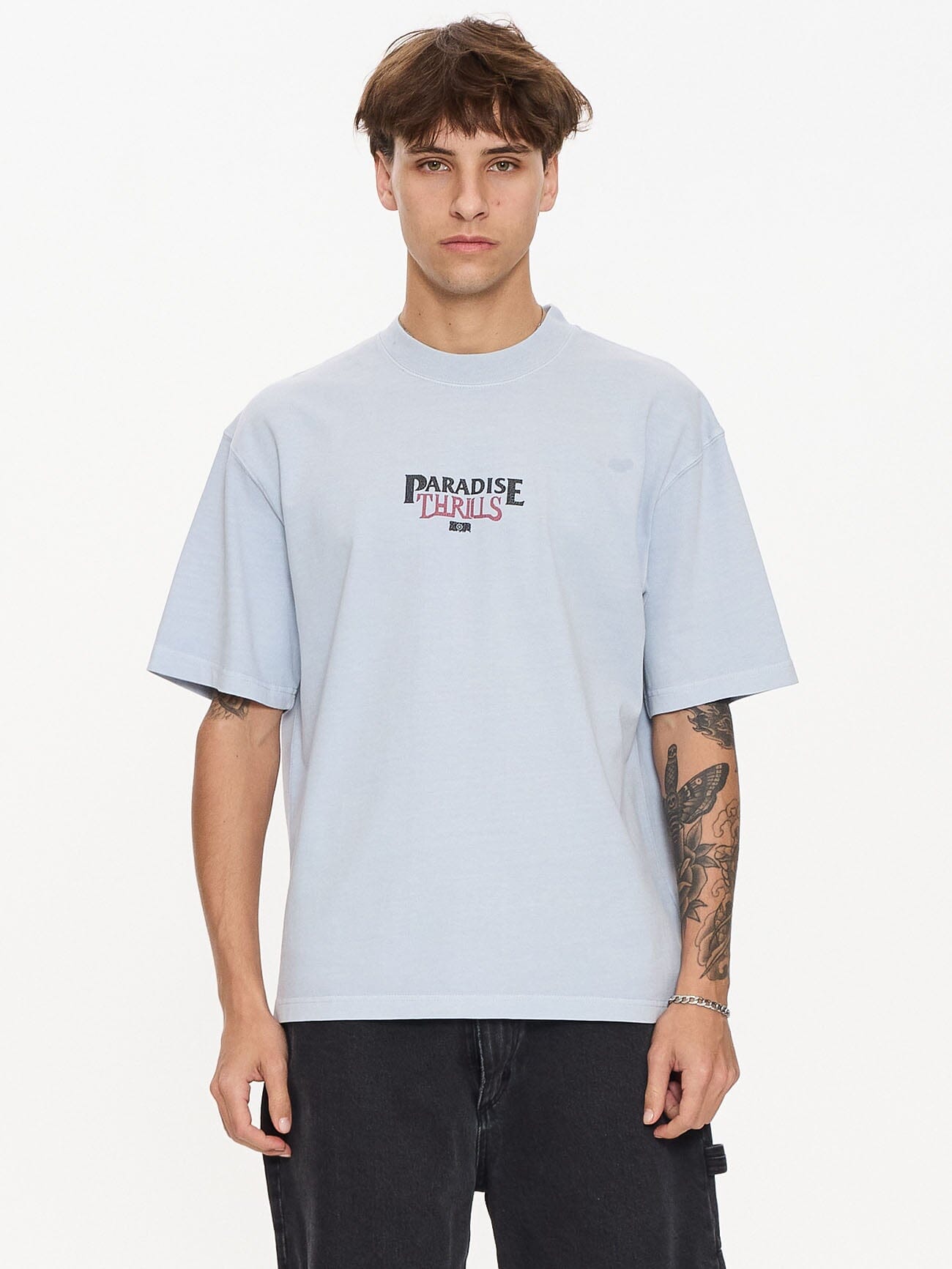 Male model wearing our Thrills Paradise Valley Box Fit Oversize Short Tee in Blue standing against a plain studio background.