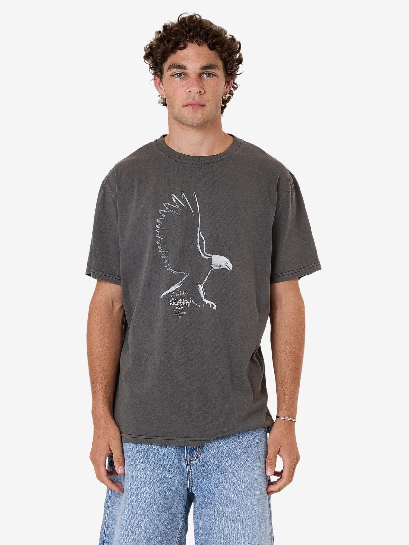 Male model wearing our Thrills Speed Metal Merch Fit Tee in Black standing against a plain studio background.