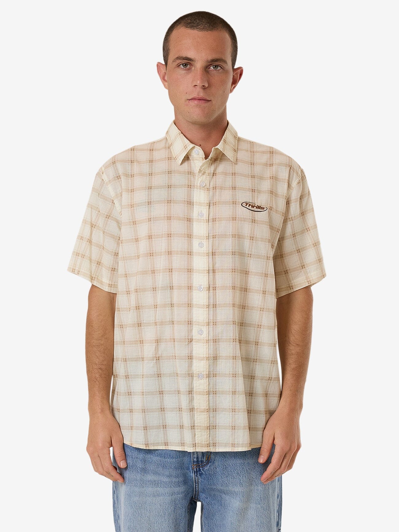 Male model wearing our Thrills Pharm Short Sleeve Shirt in Brown standing against a plain studio background.
