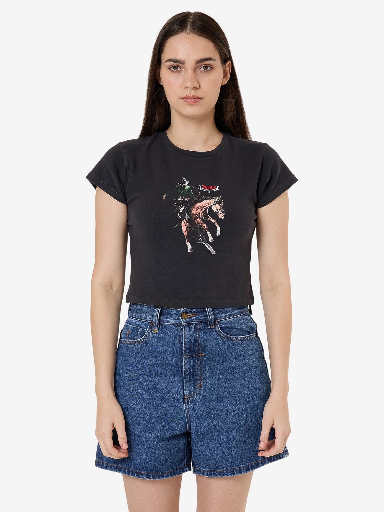 Female model wearing our Thrills Eternal Outlaw Mini Tee in Black standing against a plain studio background.