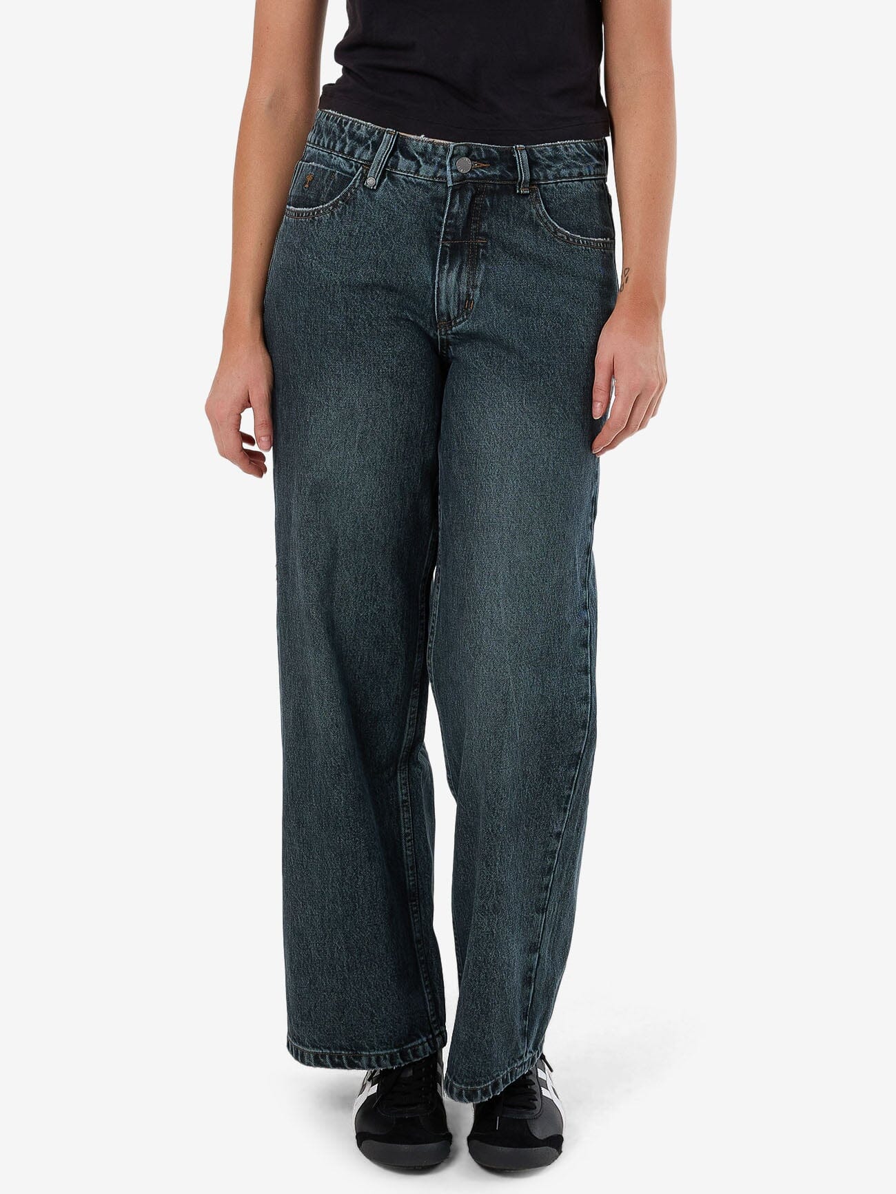 Female model wearing our Thrills Billie Low Jean in Blue standing against a plain studio background.