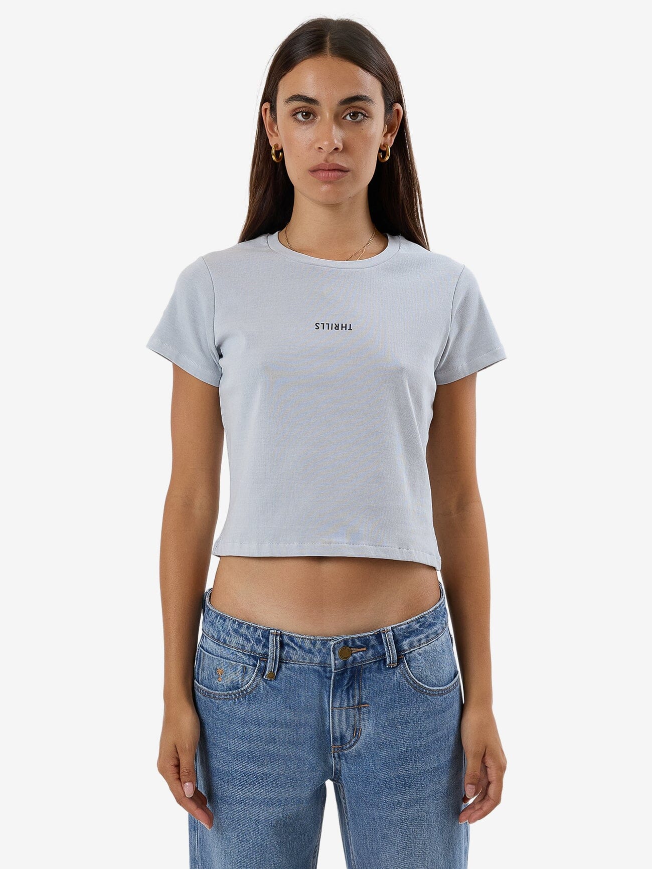 Female model wearing our Thrills Minimal Thrills Mini Tee in Grey standing against a plain studio background.
