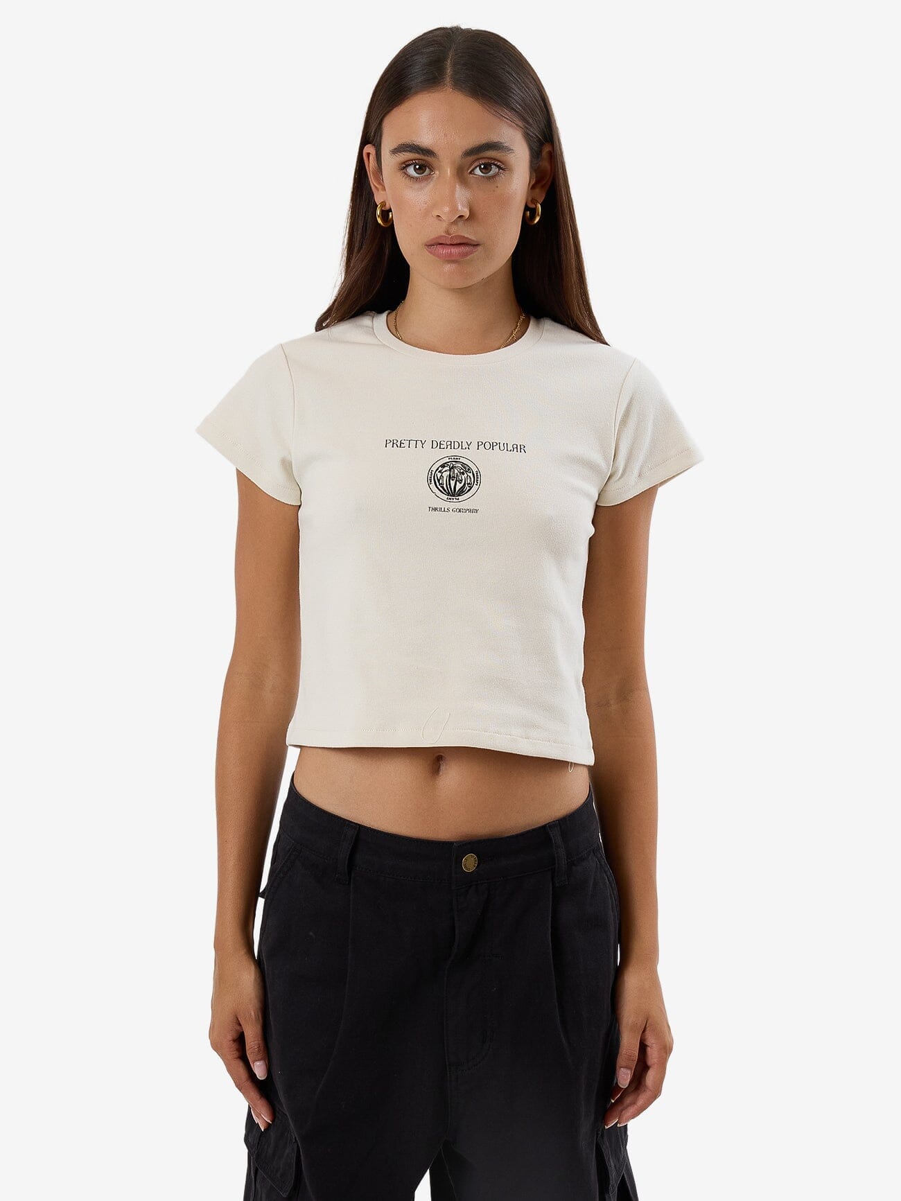 Female model wearing our Thrills Deadly Posy Mini Tee in White standing against a plain studio background.