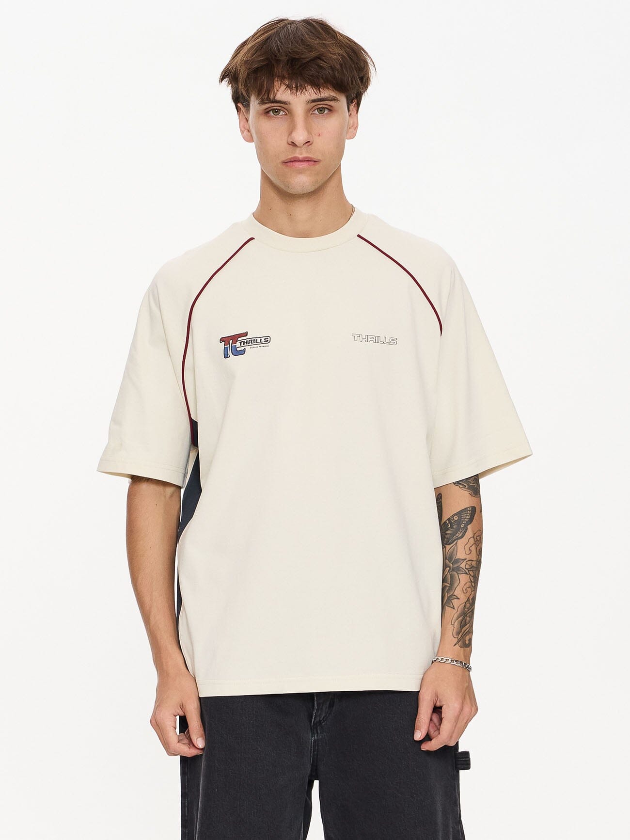 Male model wearing our Thrills Motion Box Fit Oversize Tee in White standing against a plain studio background.