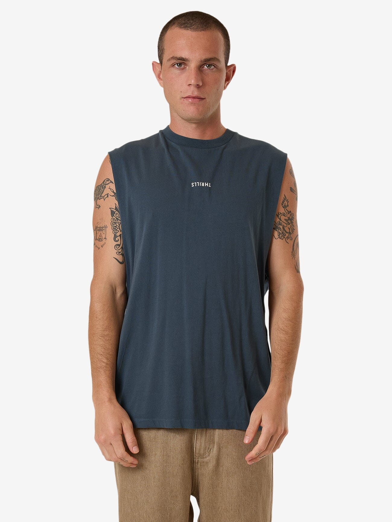 Male model wearing our Thrills Minimal Thrills Merch Fit Muscle Tee in Grey standing against a plain studio background.